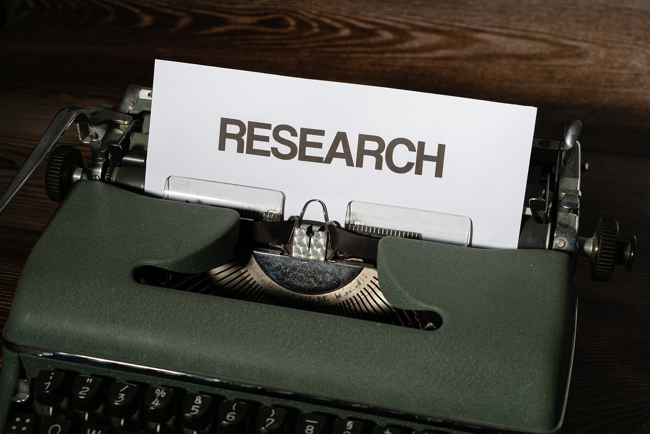 Image of a typewriter with a paper titled Research